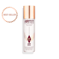 Un spray fixateur ouvert dans un flacon transparent à côté de son bouchon doré.