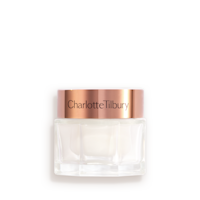 Pearly-white face cream in a glass jar with a gold-coloured lid. 